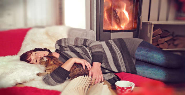 schlafende Frau mit Katze vorm Kamin